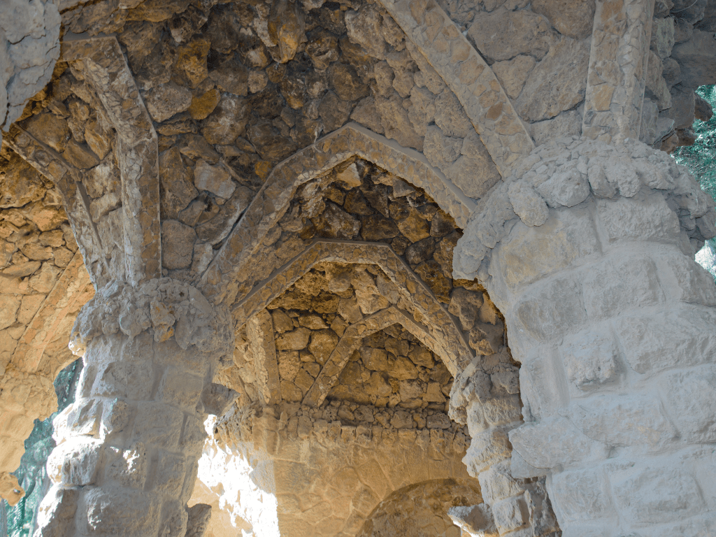 Columnas de piedra sosteniendo un camino elevado en el Parque Güell