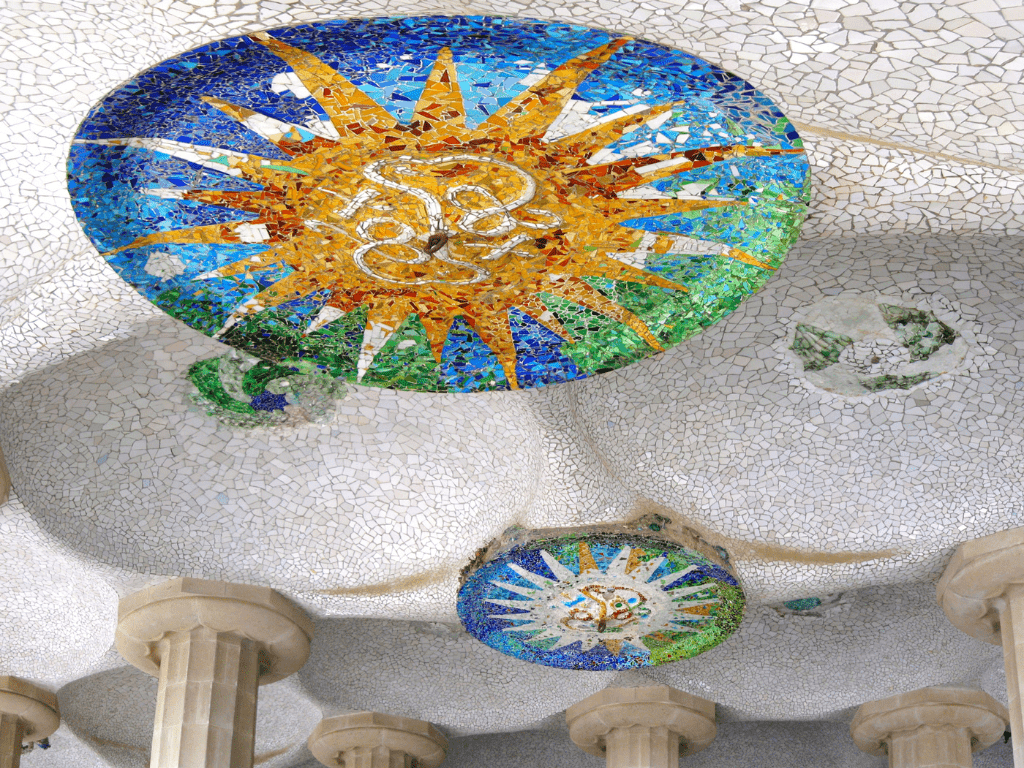 Detalle de un mosaico colorido en forma de sol en el Parque Güell