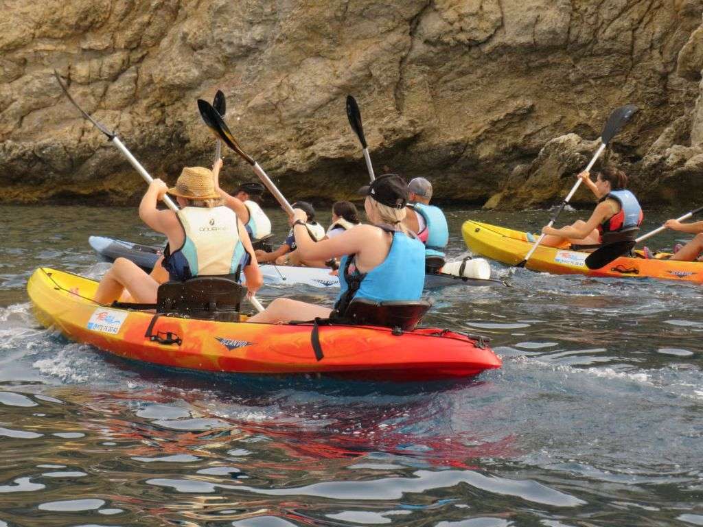 一群人站在埃尔埃斯塔蒂特(El Estartit)格里尔斯海滩(Grills)被侵蚀的石墙附近。.