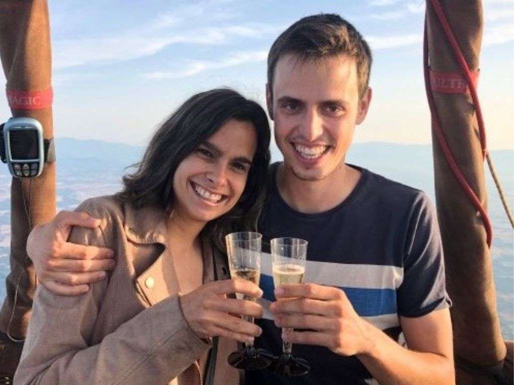 一对夫妇在飞越加泰罗尼亚的安波拉风景区后,高兴地端起两杯香槟,准备干杯。.