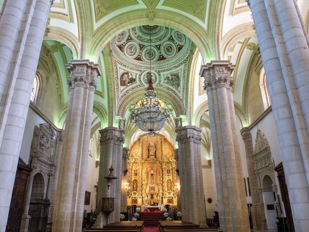 带有爱奥尼克拱门和圆柱的温暖绿色罗马风格大教堂内部照片。.