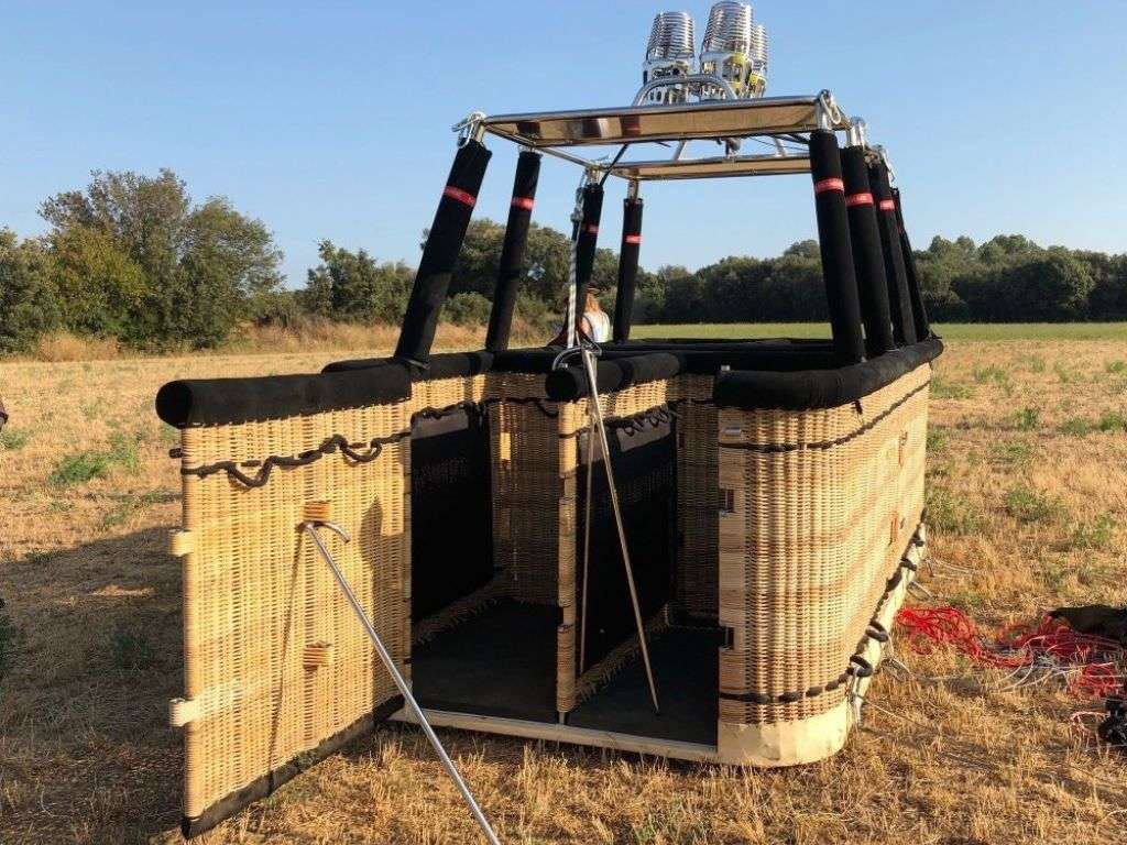 图中的荒地上有一个热气球。热气球已经准备就绪,随时可以让一群人升空。.