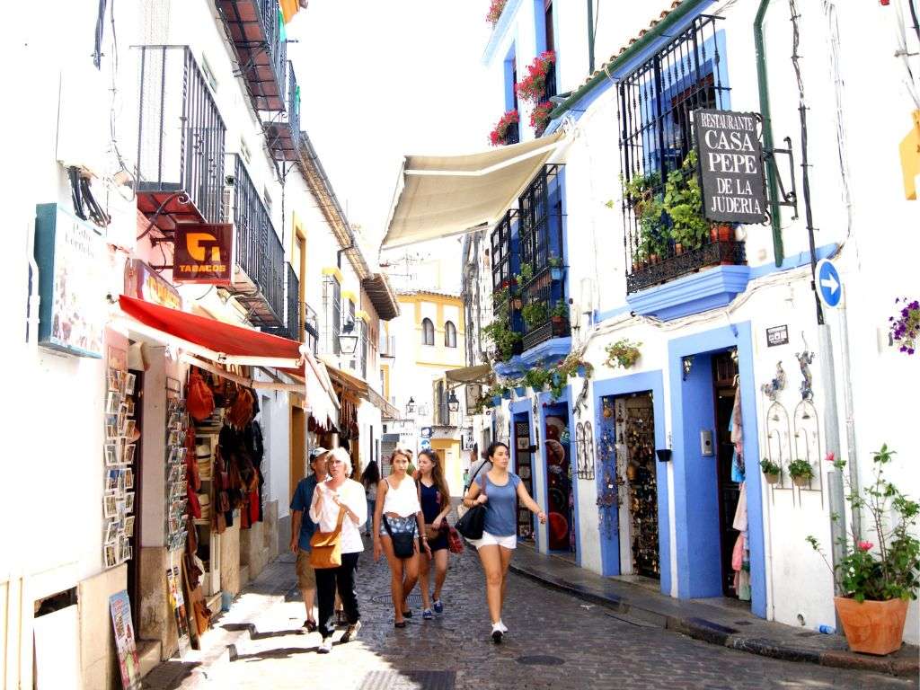 Foto de el centro de Córdoba donde se puede observar gente en su día-a-día. Se puede ver un estanco, y un restaurante.