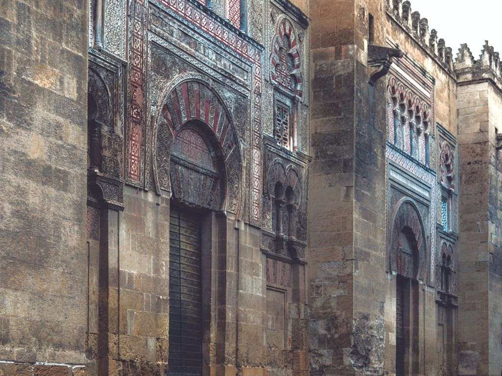 Foto de la fachada de la Mezquita de Córdoba, donde podemos observar la puerta y sus colores desgastados por el paso del tiempo.
