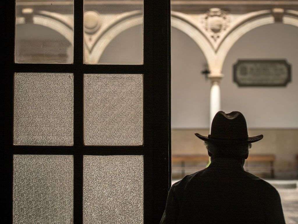 一位老人走到哈恩标志性建筑之一的室外庭院中。照片运用了当天的光线和色彩。.