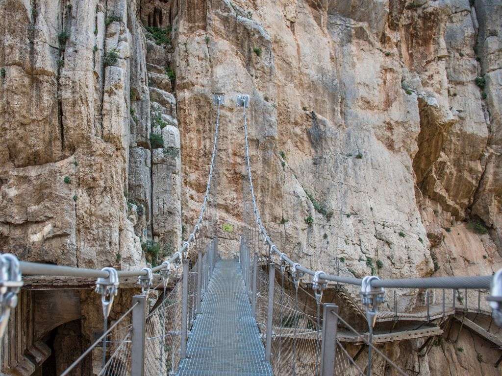 Caminito del Rey 岩石结构之间的桥梁。. 卡米尼托-德尔-雷伊(Caminito del Rey)岩壁上的一座桥的照片。.