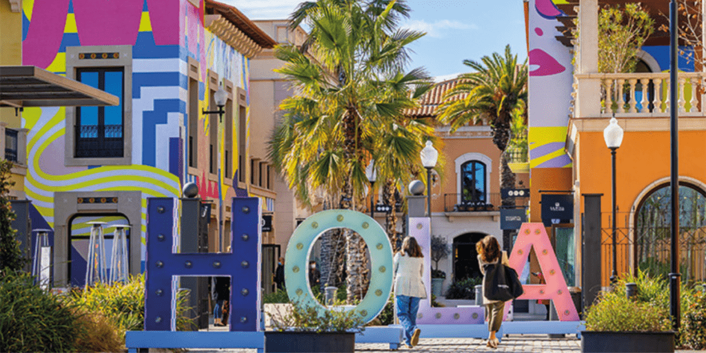 Entrada del servicio La Roca Village Shopping Express, con un letrero distintivo que guía a los visitantes hacia el punto de partida de un servicio de autobús exclusivo para compradores.