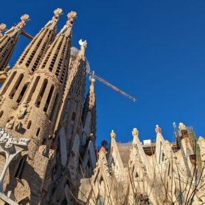 Vista lateral de la Sagrada Familia mostrando sus intrincadas torres y detallados elementos arquitectónicos, reflejando el estilo único de Antoni Gaudí