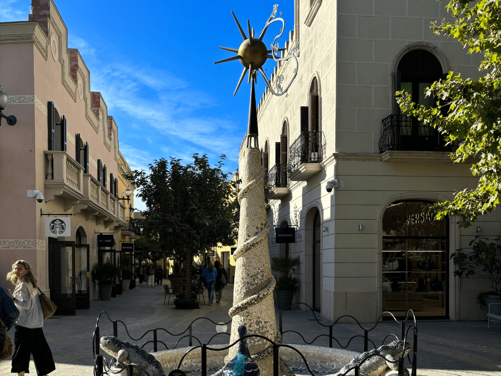 Réplica de la salamandra de Gaudí en una fuente decorativa en La Roca Village, simbolizando el arte y diseño catalán.