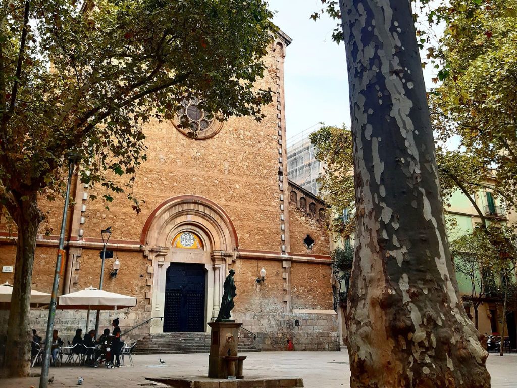 Vista lateral de la Iglesia de Sant Joan de Gràcia, mostrando el detalle arquitectónico y las ventanas.